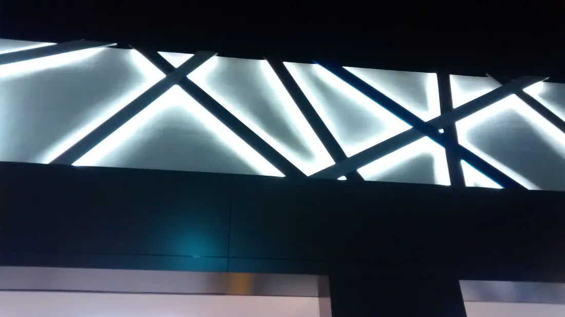 Friso de fachada de cine con iluminación indirecta en patrón geométrico