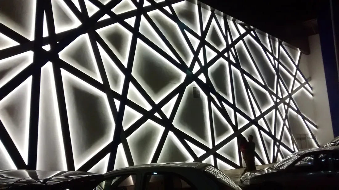 Fachada exterior de cine con friso luminoso y estructura geométrica
