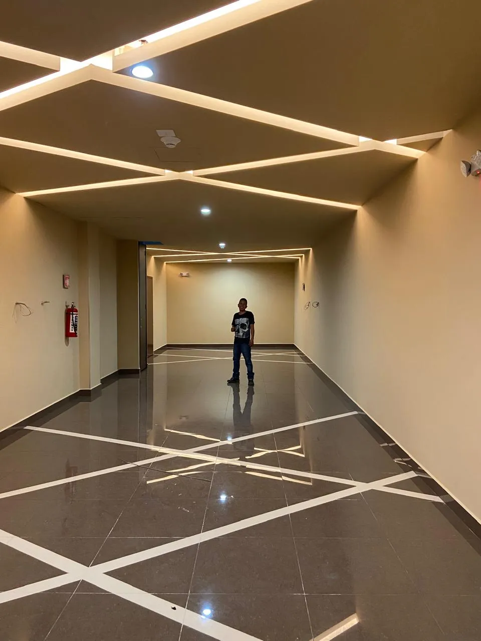 Pasillo de cine con plafón de líneas LED entrecruzadas