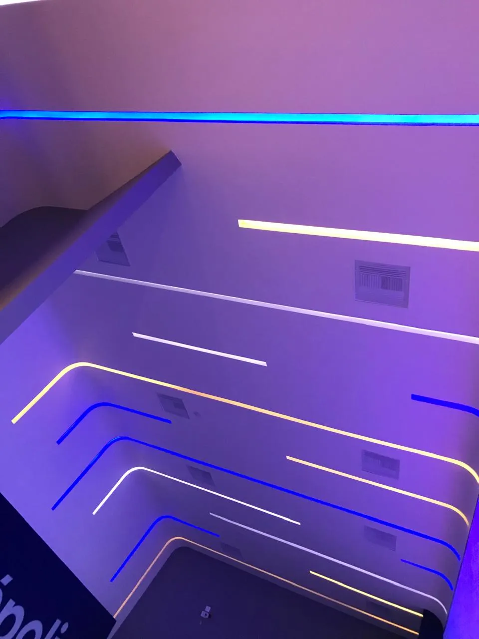 Detalle de perfiles LED en blanco, ámbar y azul integrados en muro