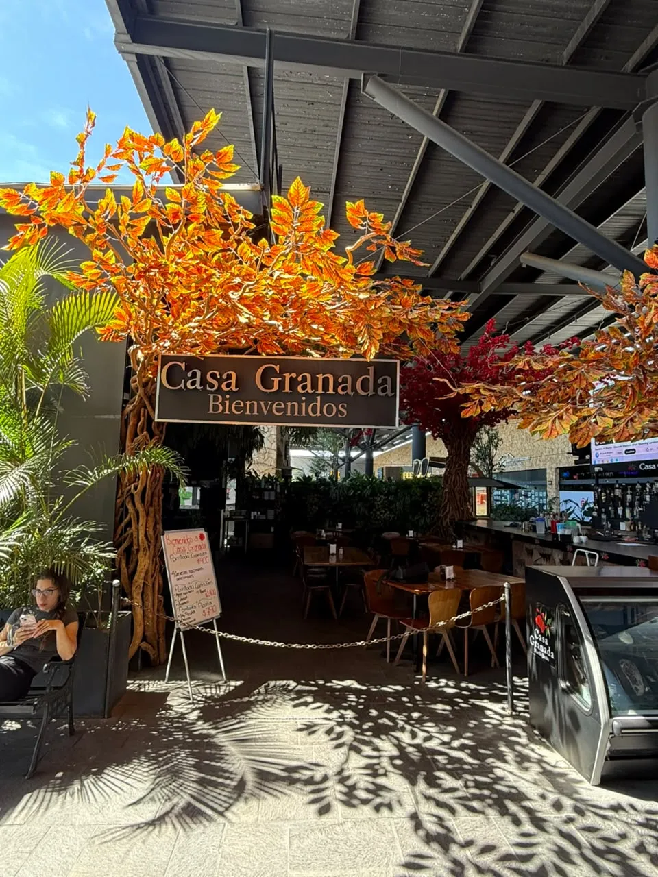 Elemento decorativo tipo árbol con iluminación integrada en acceso de restaurante