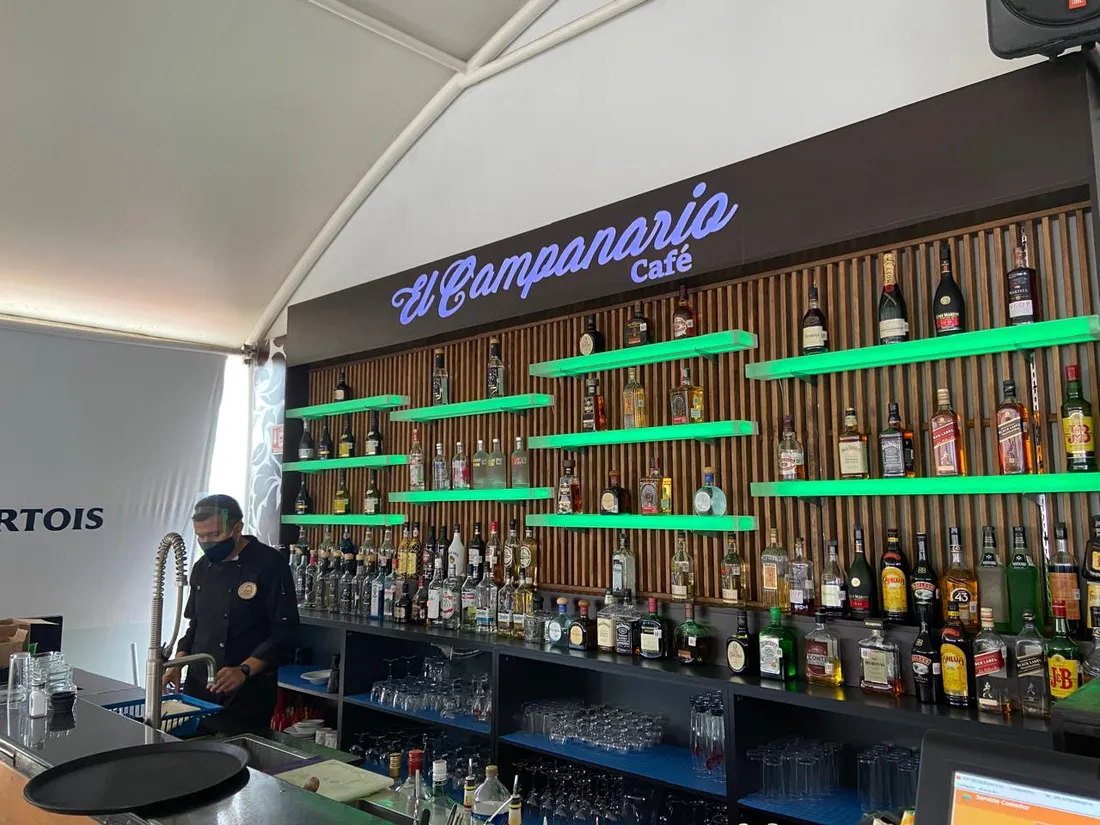 Barra de café con letrero luminoso y repisas iluminadas en verde