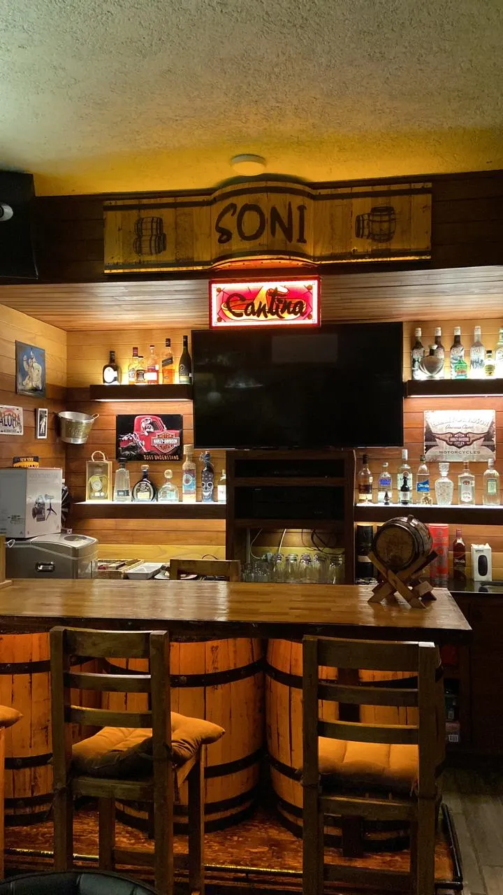 Barra tipo cantina con letrero luminoso y repisas iluminadas