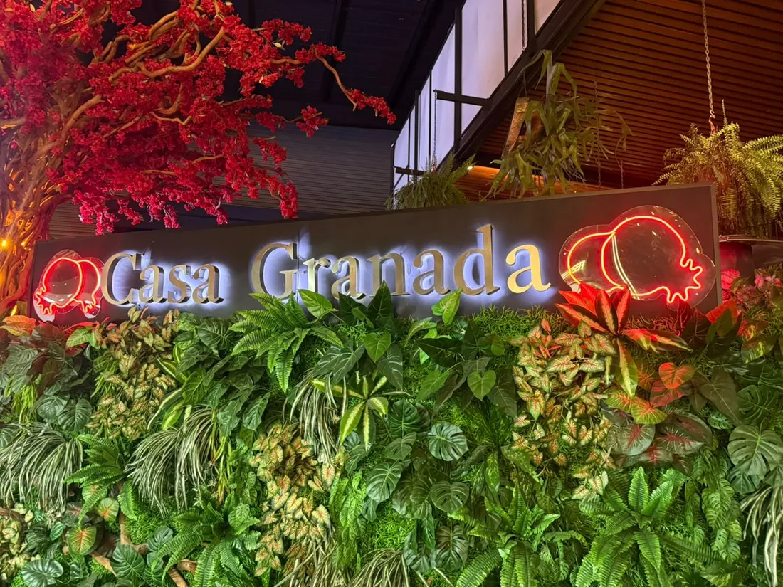 Letrero de restaurante con muro verde y acento en neón
