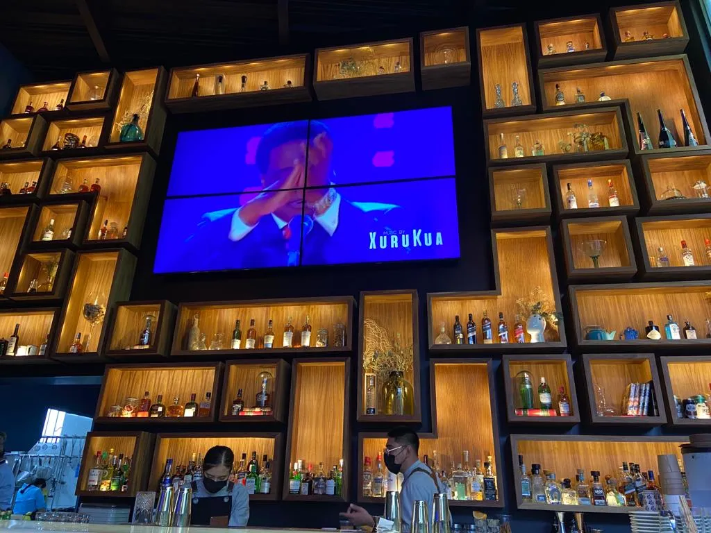 Muro decorativo con nichos de madera retroiluminados en composición tipo mosaico