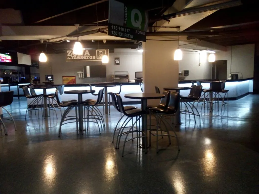 Área de servicio de restaurante con luminarias colgantes cálidas